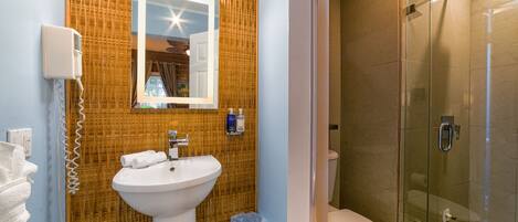 A bathroom with a sink, mirror, and toilet.