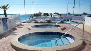 Ein Poolbereich mit zwei Whirlpools und Blick auf den Ozean.