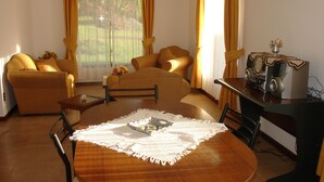 A living room with a wooden dining table, two sofas, and a coffee table. - Turismo Vinapu (Hanga Roa)
