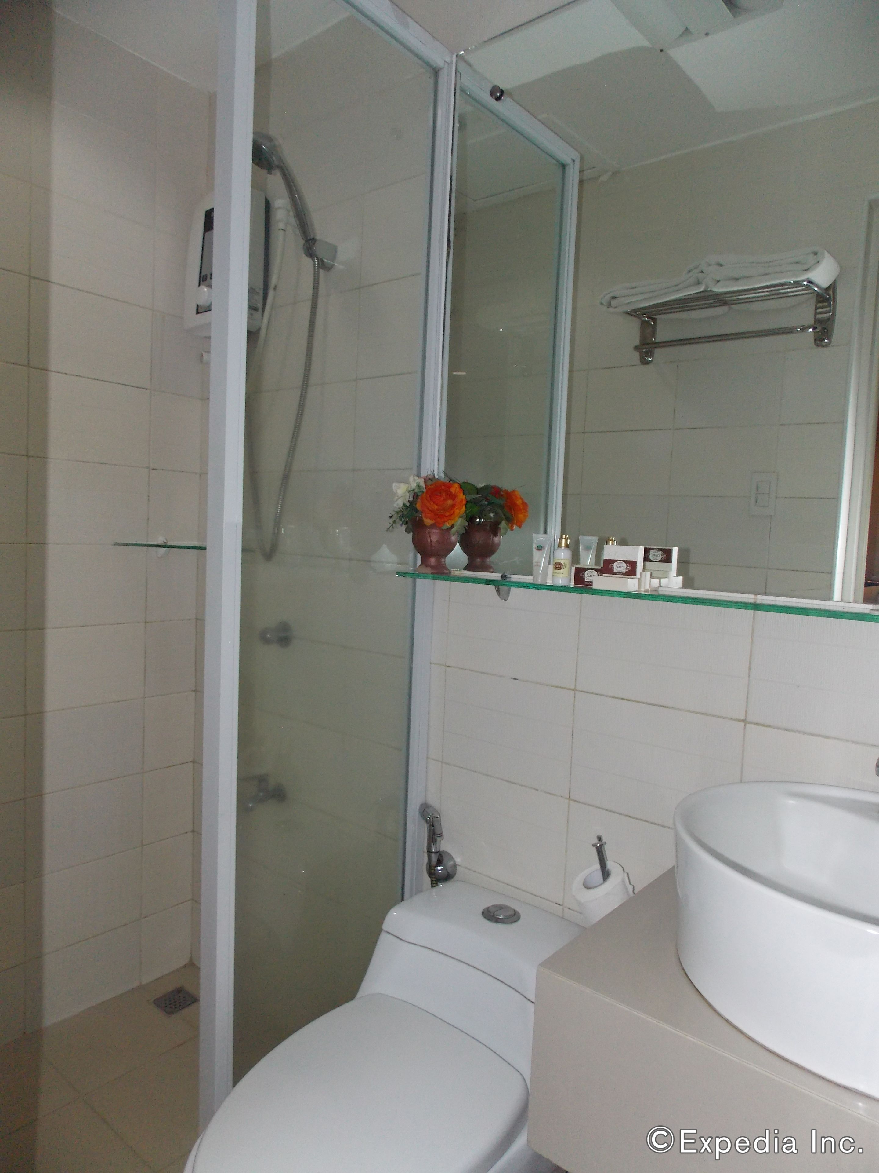 Une salle de bain moderne avec une douche à parois de verre, des toilettes, un lavabo et un miroir.