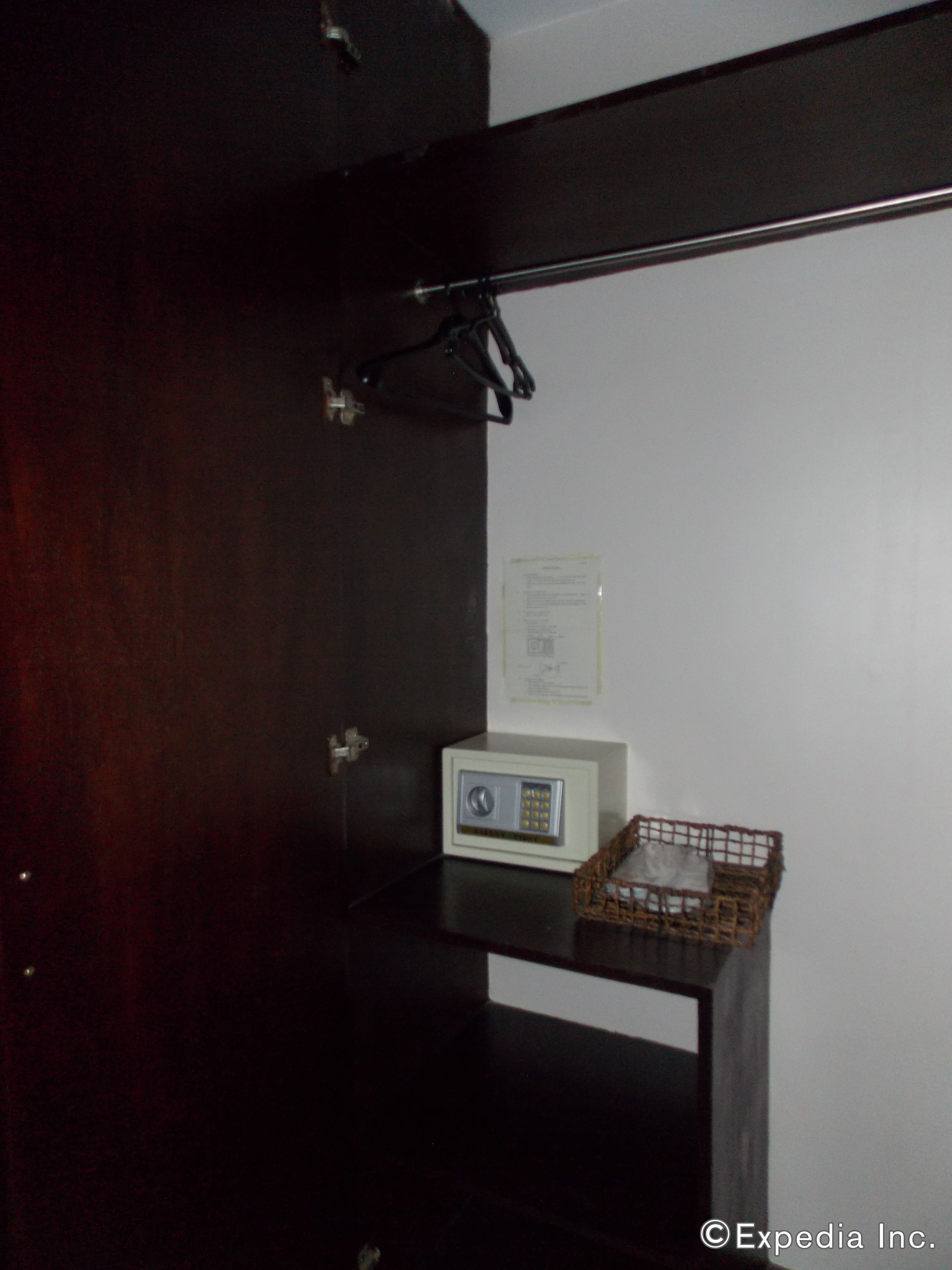 Ein dunkler Holzschrank mit einem weißen elektronischen Gerät auf einer Ablage und einem kleinen Korb.
