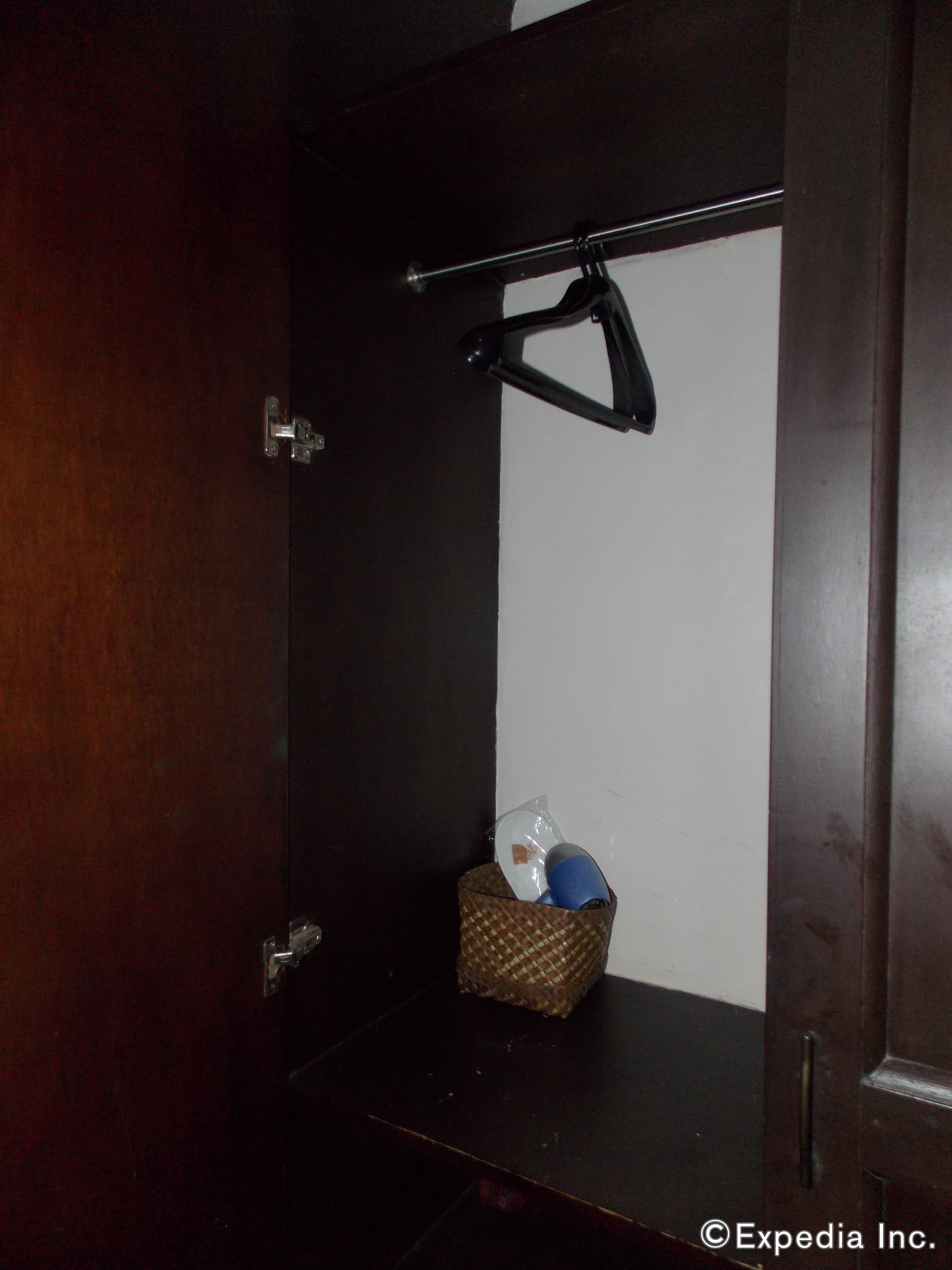 A dark wooden door with a metal handle and a small woven basket containing a blue object and a clear plastic bag.