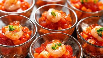 A series of clear glass cups containing a seafood dish with shrimp and roe, garnished with green onions.