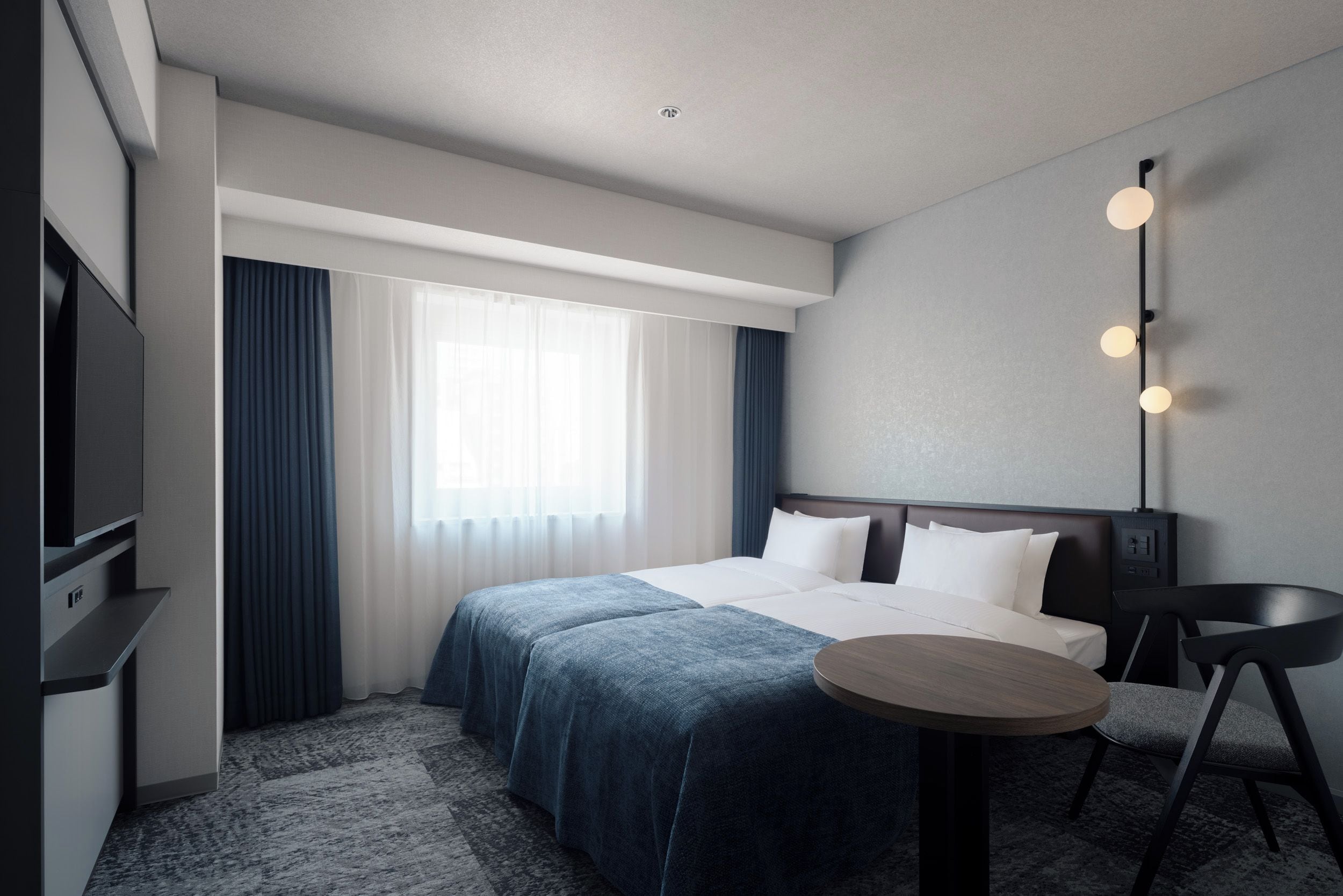 A hotel room with a bed, a desk, a chair, a TV, and a window with curtains.