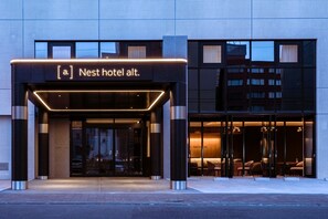 The exterior of a hotel with a modern design, featuring a prominent entrance with glass doors and a sign above. - Nest hotel alt. Sapporo odori (Sapporo)
