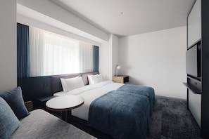A hotel room with a bed, a bedside table, a chair, a TV, and a window with curtains. - Nest hotel alt. Sapporo odori (Sapporo)