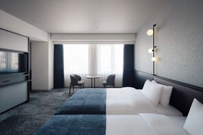 A hotel room with a bed, a desk, a television, two chairs, and a window with curtains. - Nest hotel alt. Sapporo odori (Sapporo)