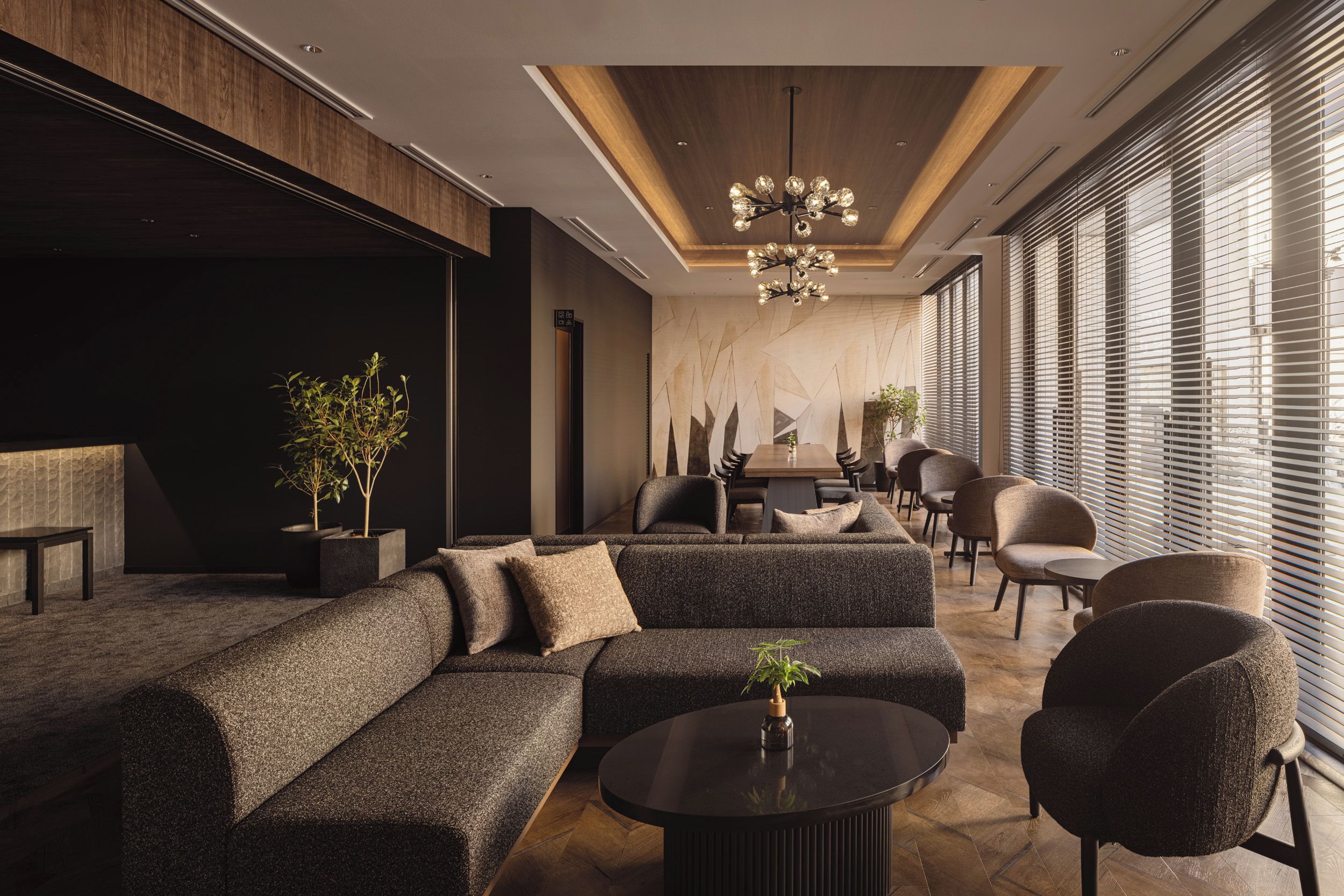 Un área de estar moderna con un sofá modular, una mesa redonda de centro y una mesa de comedor con sillas.
