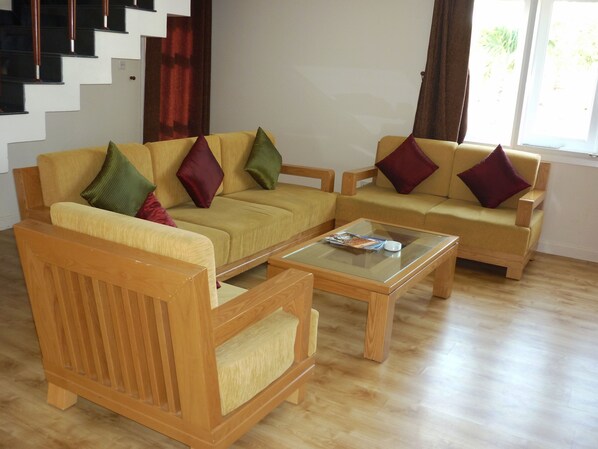 A living room with two sofas, a coffee table, and a wooden chair.