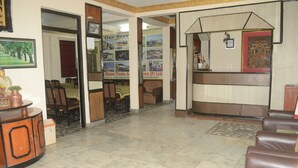 A reception area with a counter, seating, and a corridor leading to a dining area. - Kathmandu Friendly Home (Kathmandu)