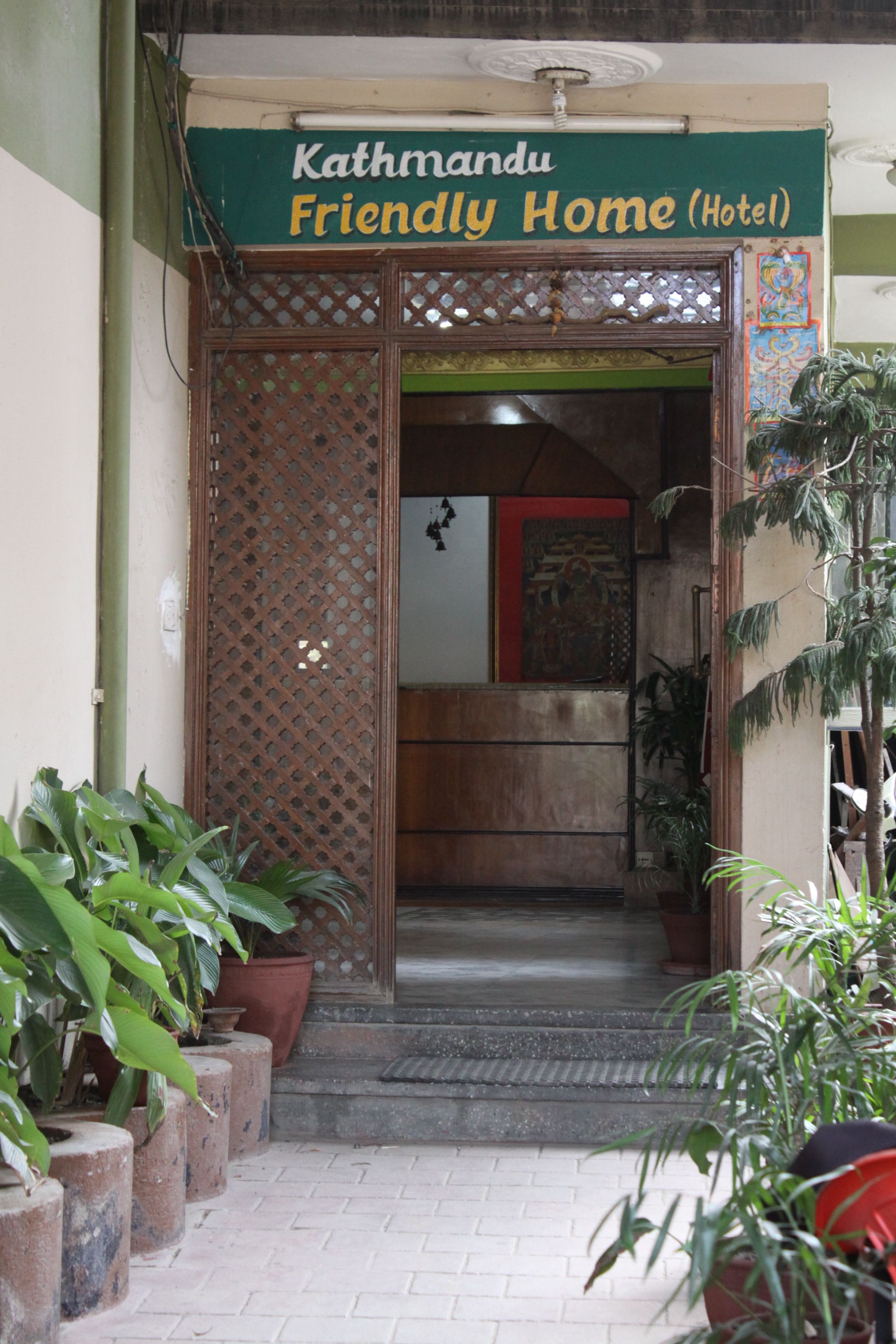 L’entrée de l’hôtel Kathmandu Friendly Home, avec sa porte en treillis de bois et ses plantes en pot.