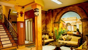 Un vestíbulo con una escalera, un sofá, una mesita de café y un mural en la pared.