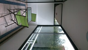 A room with a glass ceiling, a green folding screen, and a white wall.