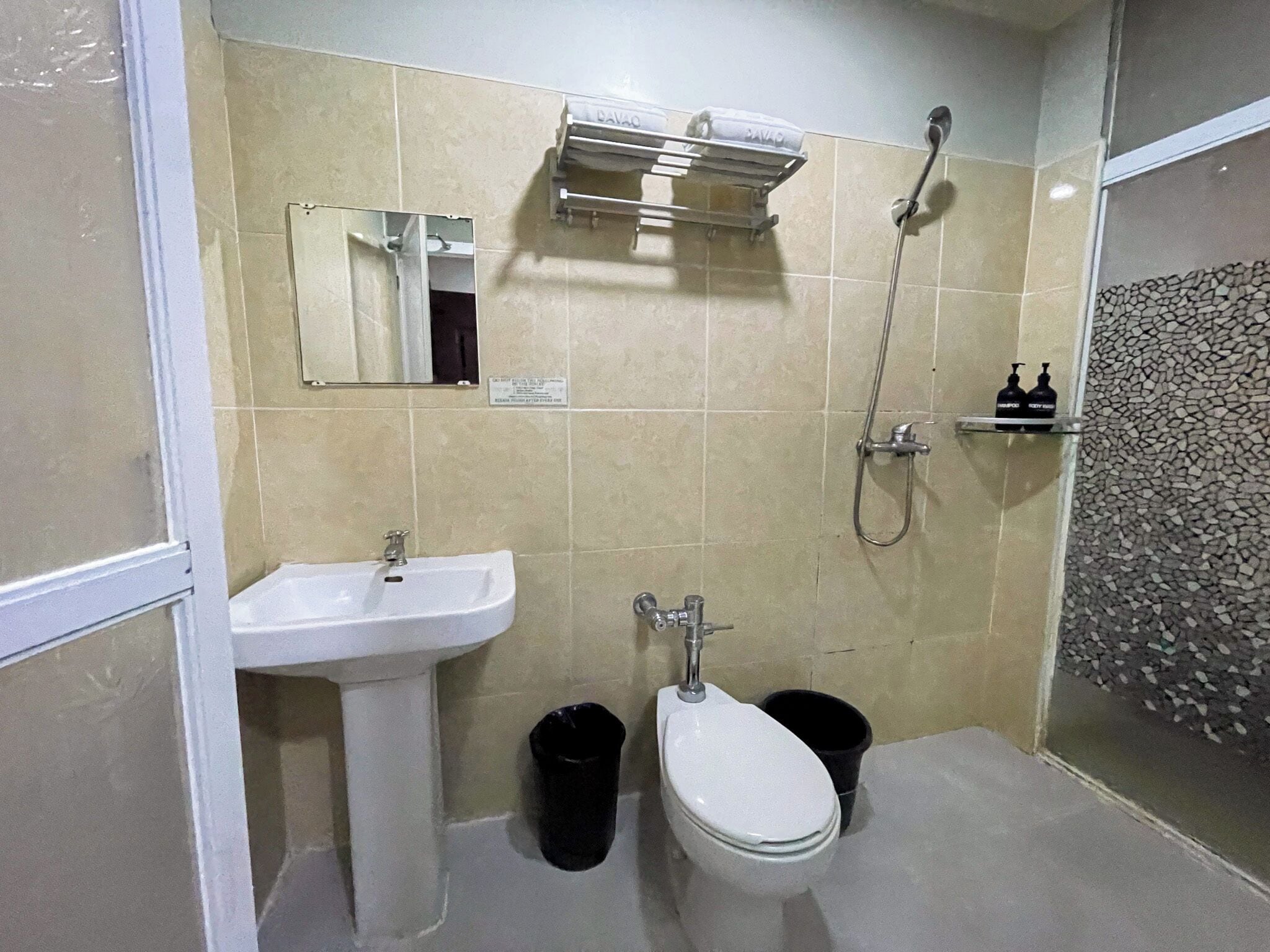 Ein Badezimmer mit Waschbecken, Toilette, Dusche und Spiegel.