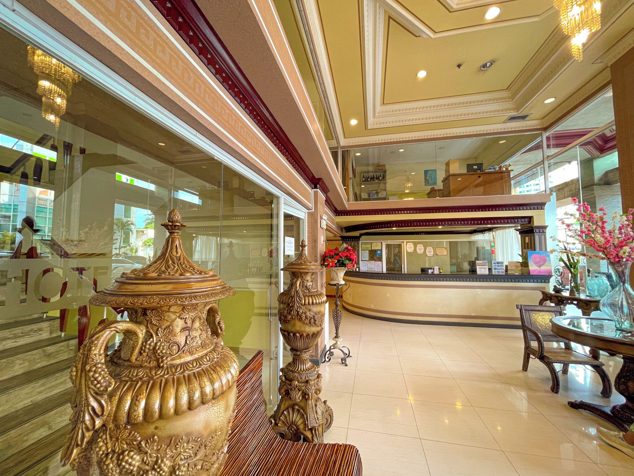 A lobby with ornate furniture, a reception desk, and a glass partition.