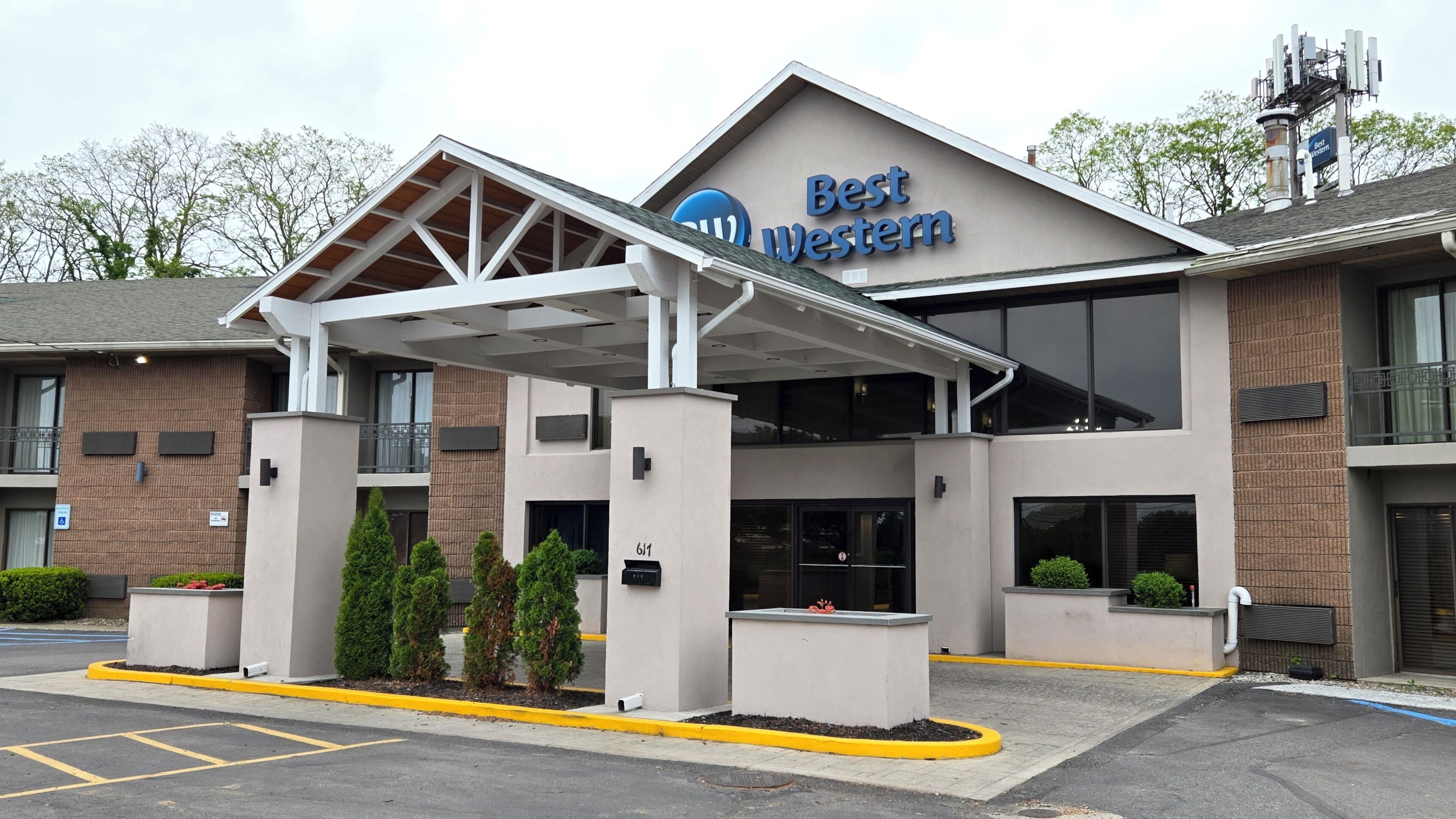 A Best Western hotel with a covered entrance, outdoor seating, and a parking lot.