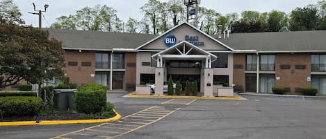 Un hotel Best Western con estacionamiento, un cartel y la fachada del edificio.