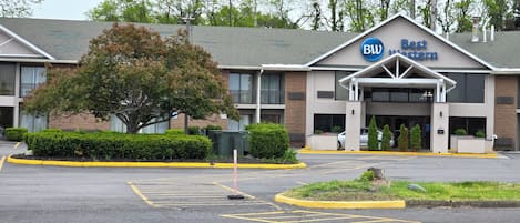 A Best Western hotel with a parking lot and a large tree in front.