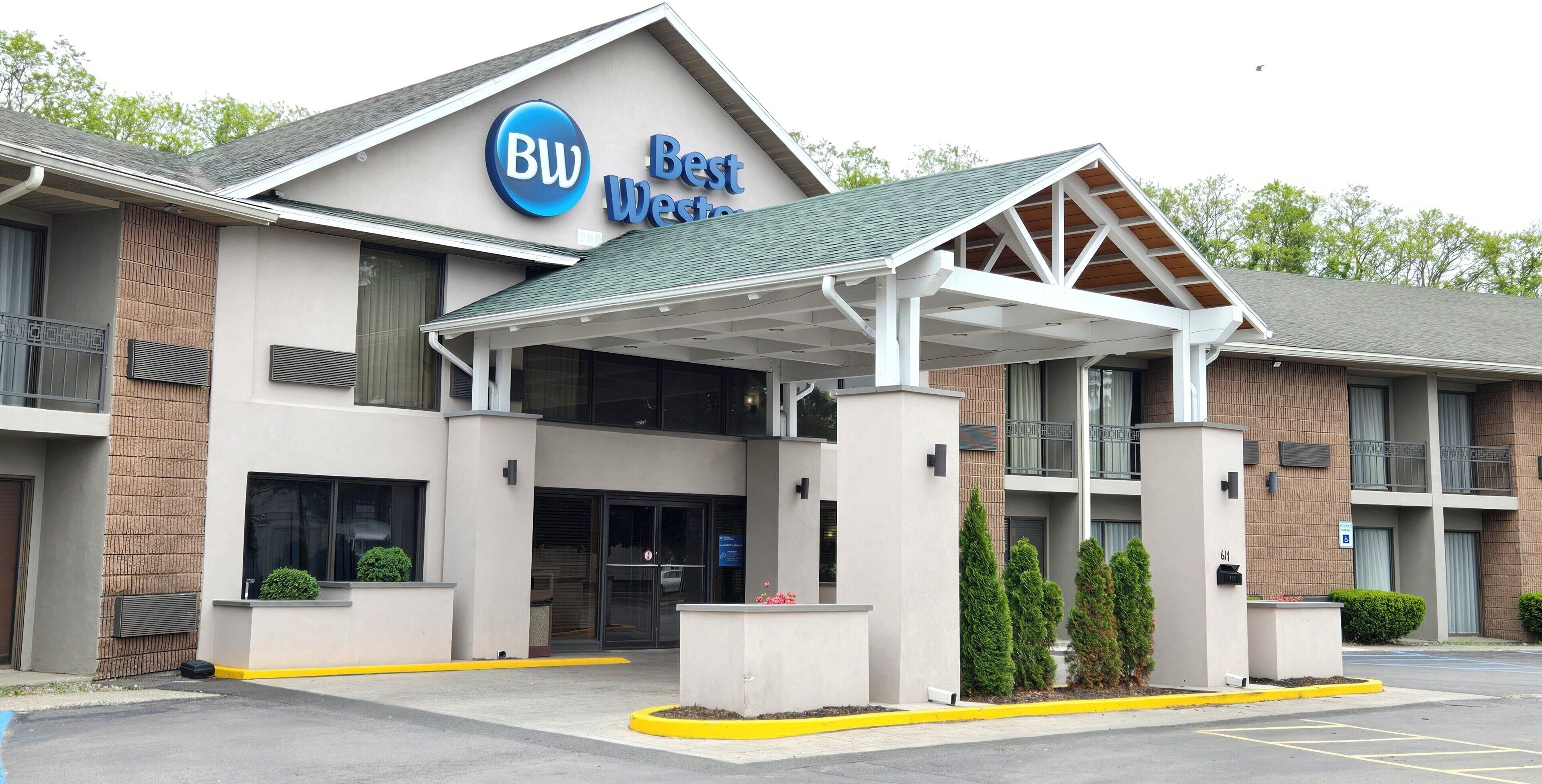 Un hotel Best Western con entrada cubierta, ventanas amplias y estacionamiento.