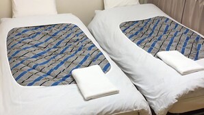 Una cama doble con una colcha estampada y una almohada blanca.