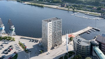 En høj bygning med parkeringsplads og lystbådehavn.