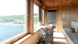 A sauna room with wooden walls and large windows overlooking a lake. - Elite Plaza Hotel, Örnsköldsvik (Ornskoldsvik)