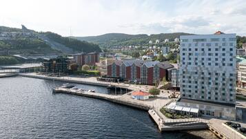Hotel amb vistes al mar de disseny modern, amb una gran façana de vidre, un moll i vista als voltants de la ciutat i les colines.