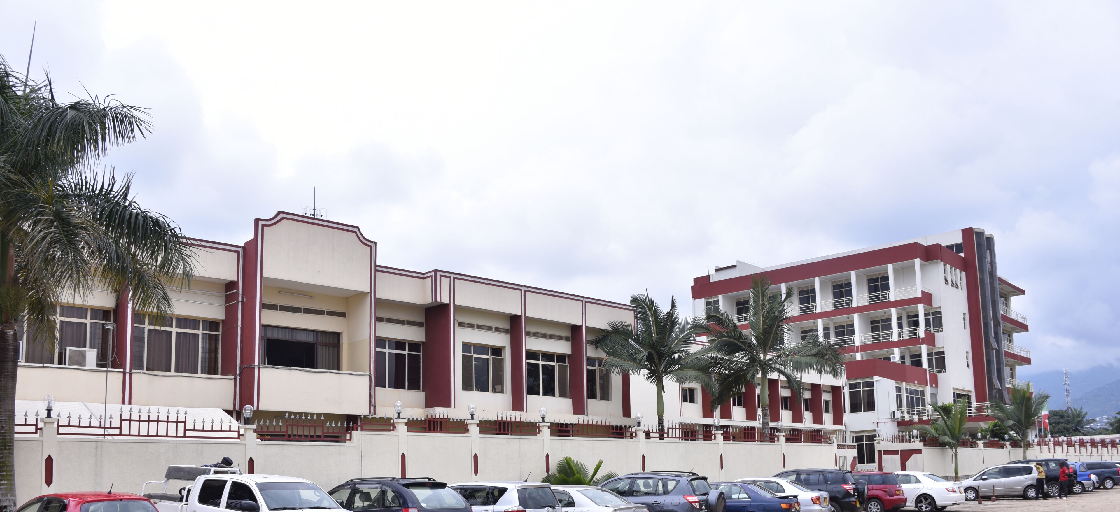 A multi-story building with a parking lot in front.