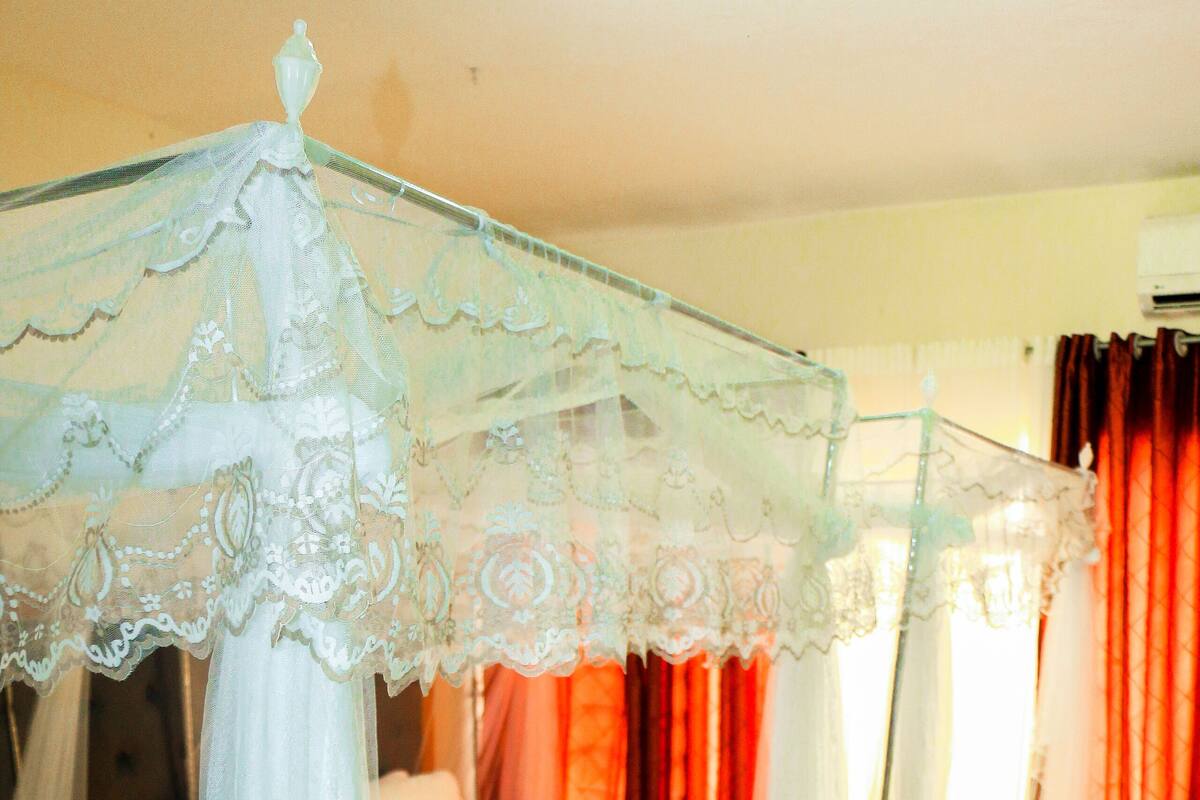 Une chambre d’hôtel avec deux lits, chacun surmonté d’un baldaquin et recouvert d’une couvre-lit assorti.