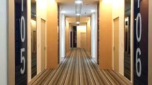Un pasillo de hotel con números en las paredes que señalan los números de las habitaciones.