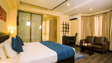 Relax in this stylish room with a large bed, desk, and comfortable sofa, offering a balcony with a view.