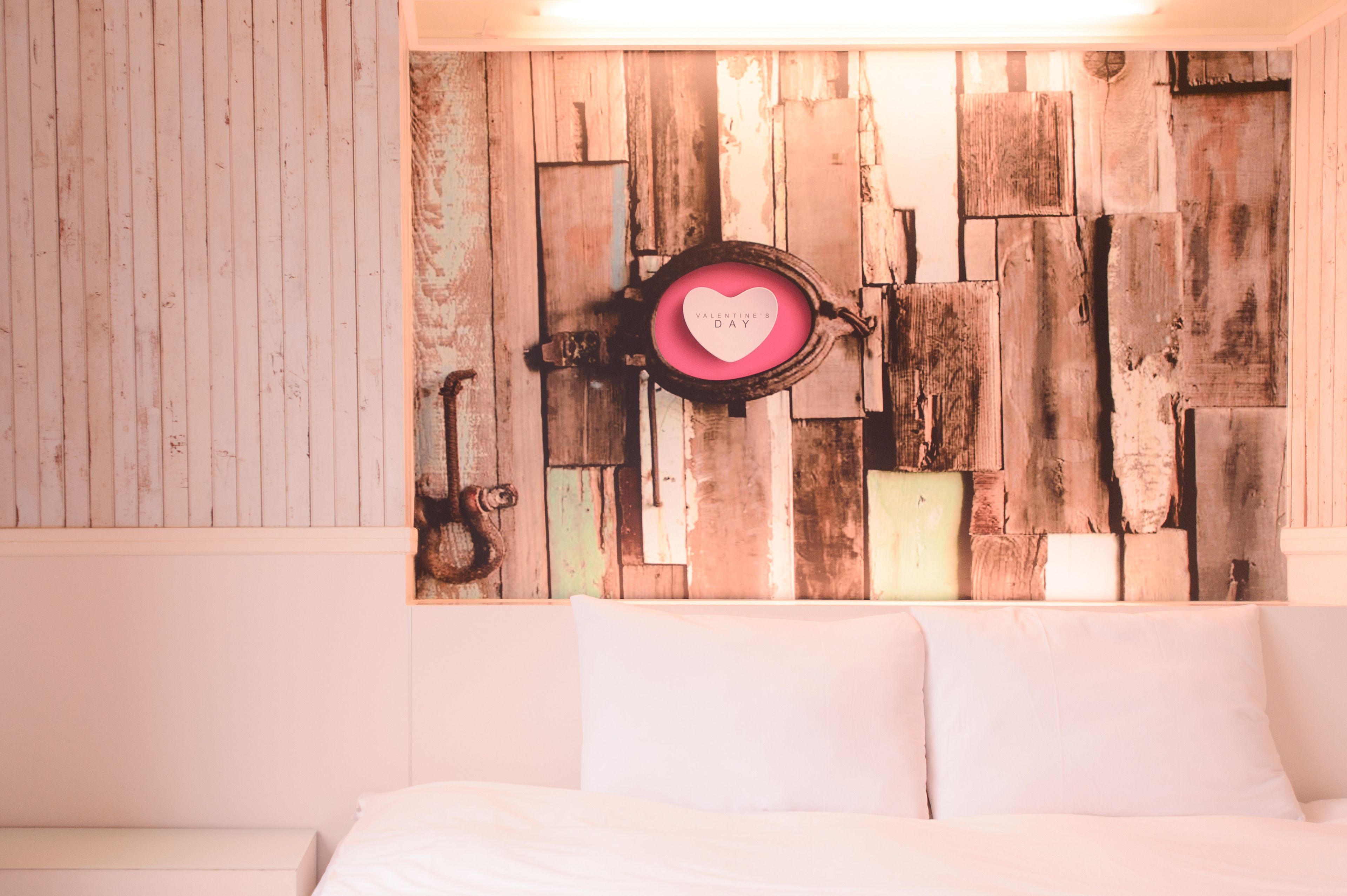 A rustic wall with a heart-shaped decoration and a sign that reads "Valentine's Day".