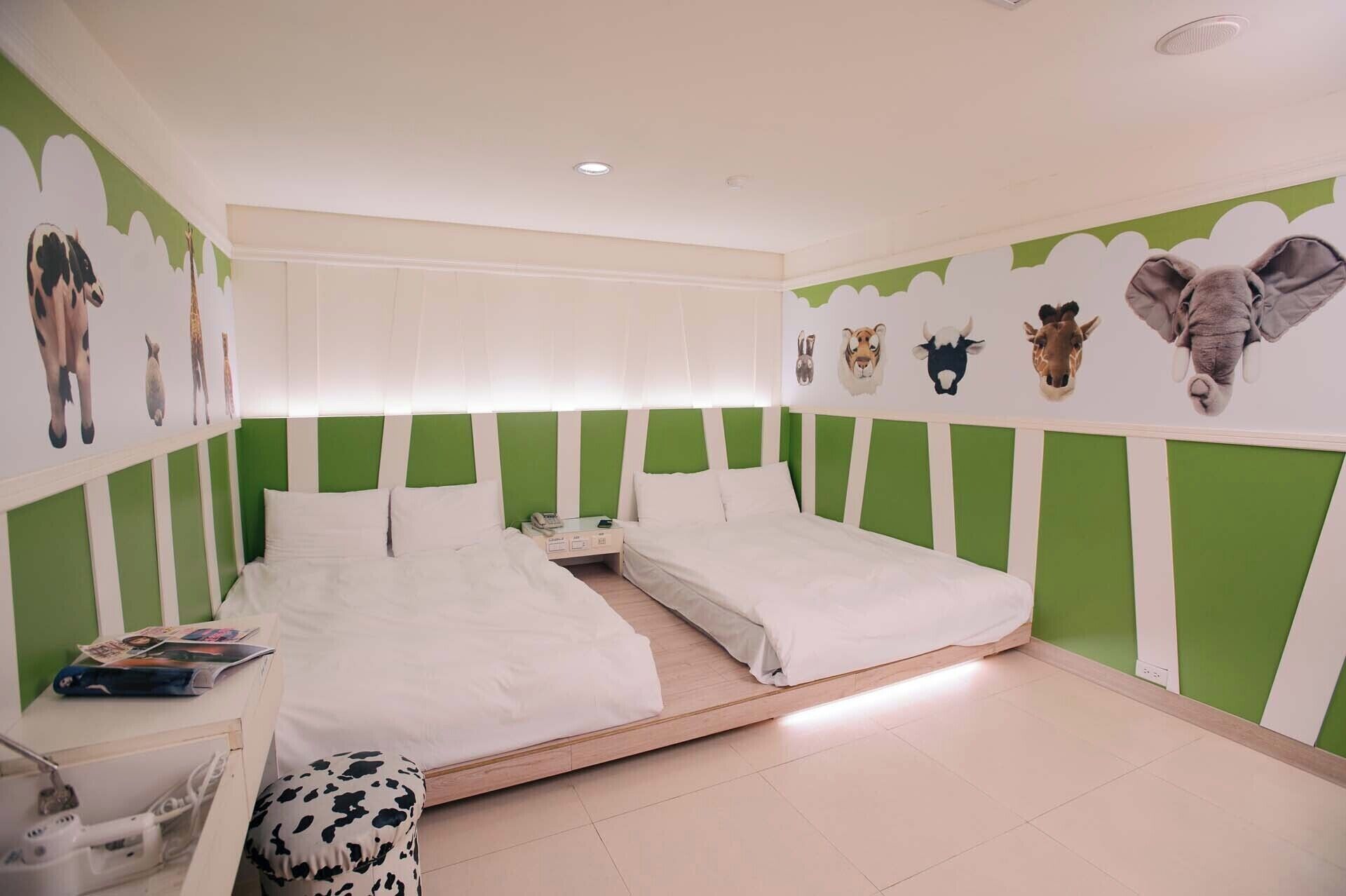 Un dormitorio con dos camas individuales, una mesita de noche, un escritorio y una silla.