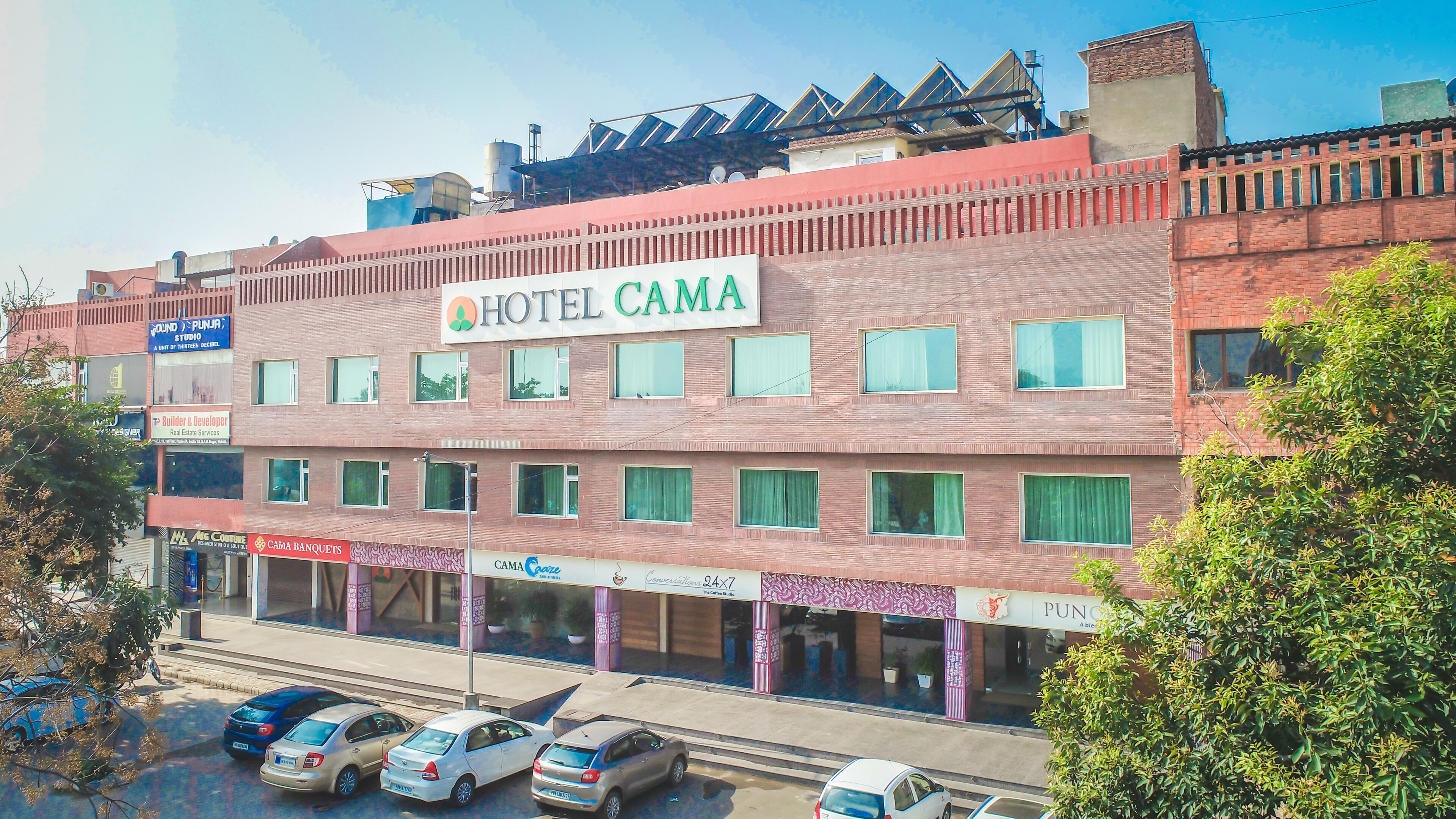 Un edificio de varios pisos con un letrero destacado que dice HOTEL CAMA.