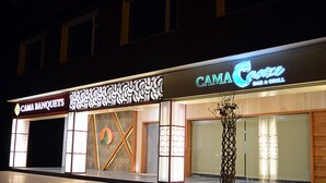 A building with multiple storefronts, including "CAMA Banquets" and "CAMA Cafe Bar & Grill". - Hotel Cama (Mohali)