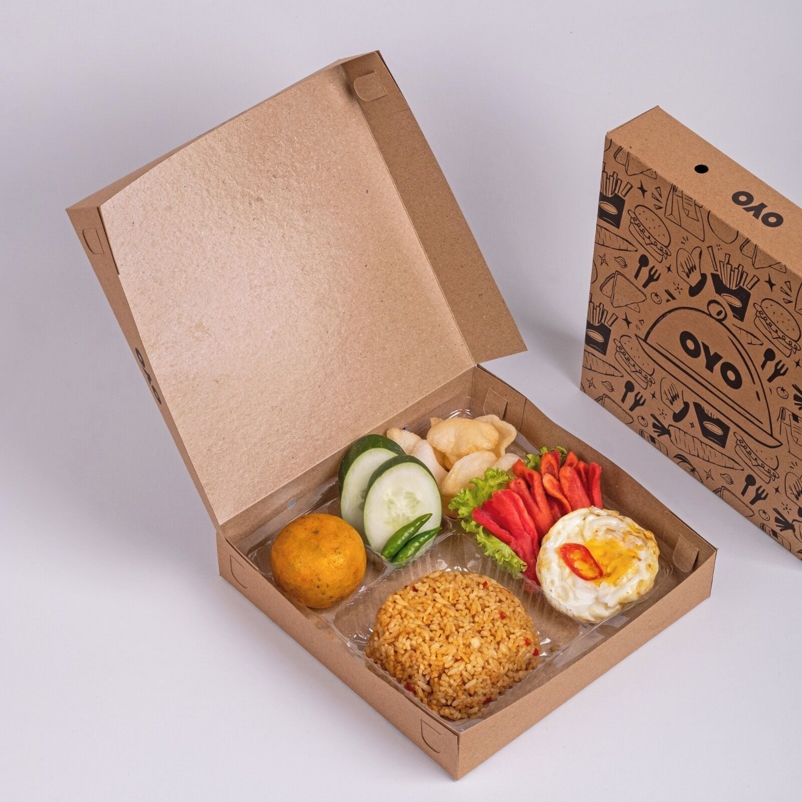 Une boîte en carton contenant divers aliments, notamment du riz, des légumes et un œuf frit.
