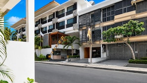 A multi-story hotel with a modern design, featuring balconies, a covered entrance, and a street view. - Palette Hotel Seminyak (Seminyak)