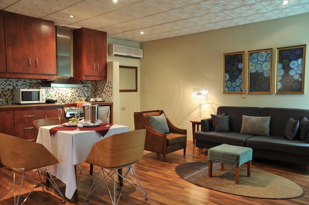 A modern kitchen with wooden cabinets, a microwave, and a dining area with a table and chairs.