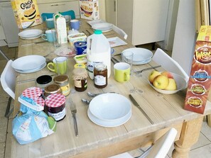 A dining table with various food items, utensils, and containers. - Kew Studios and Rooms (Richmond)