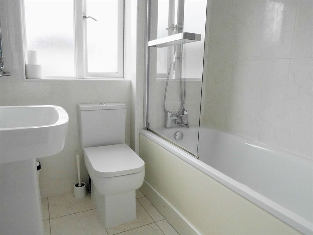 A bathroom with a toilet, sink, and shower.