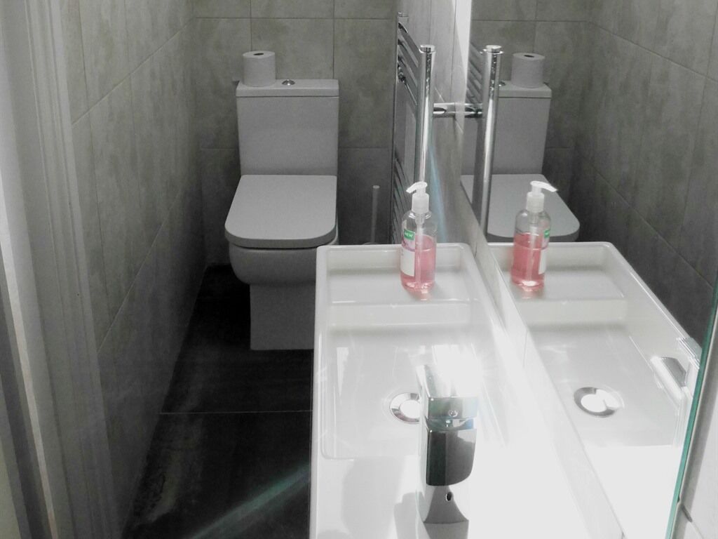 A modern bathroom with a toilet, a sink, and a mirror.