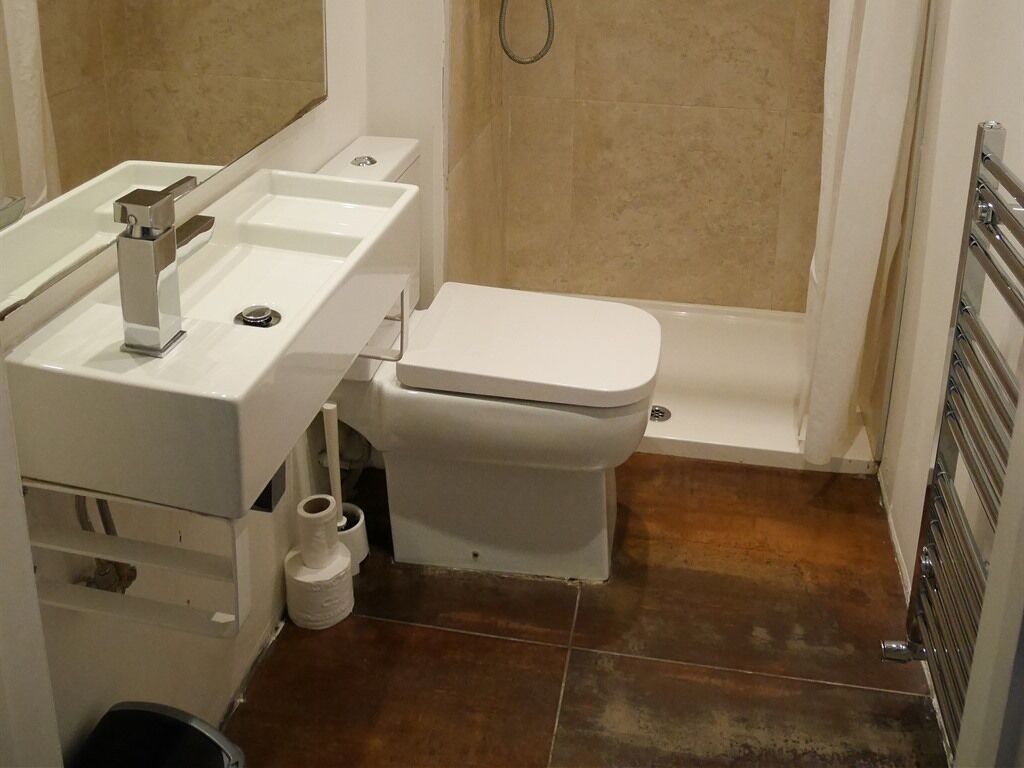 A bathroom with a toilet, sink, and shower.