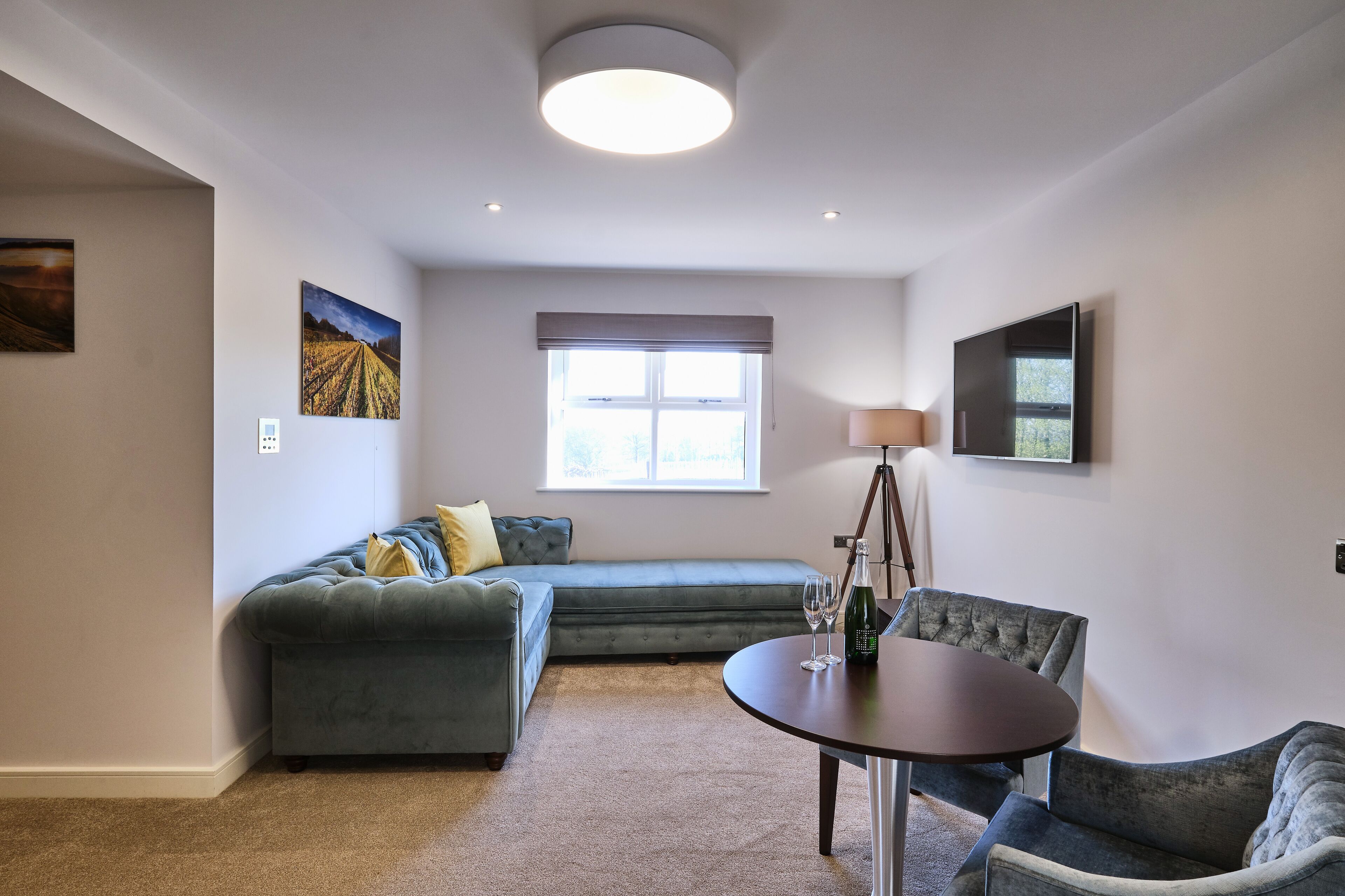 Een moderne woonkamer met een bank, een eettafel en een raam met uitzicht.