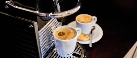 A coffee machine dispensing espresso into two cups.