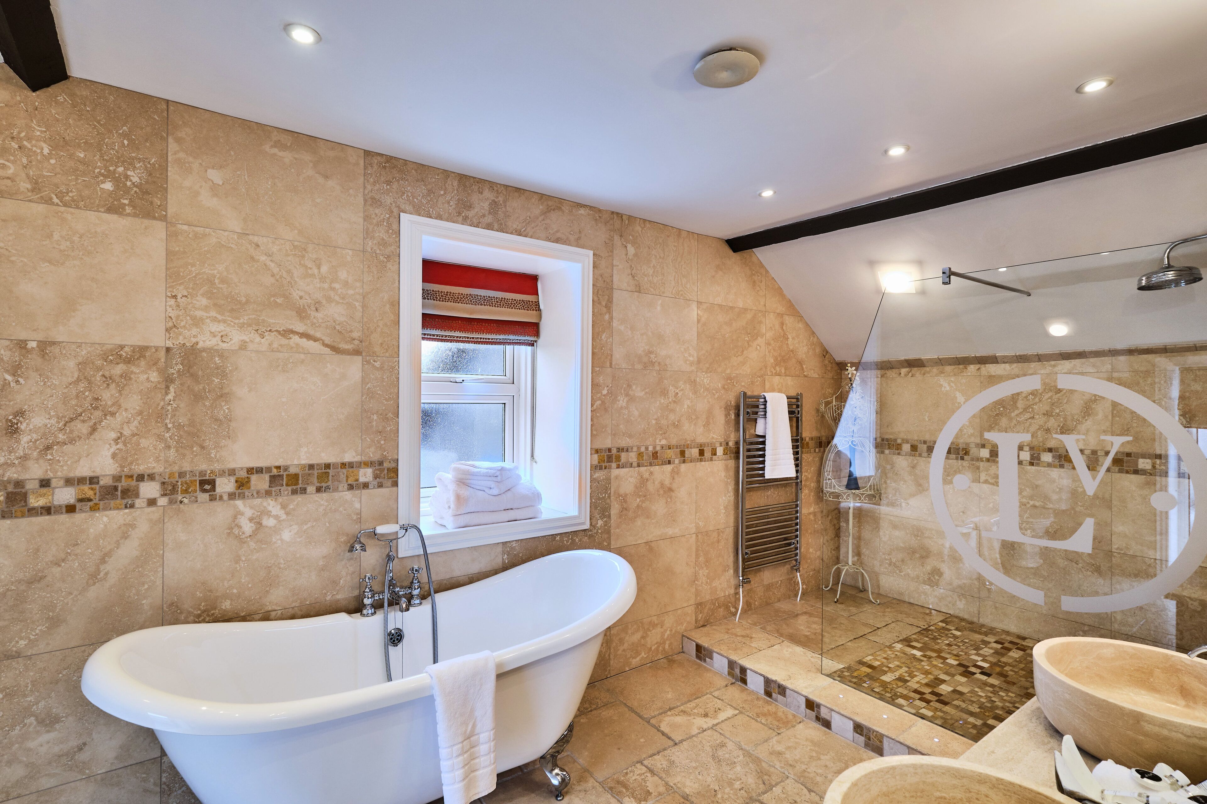 A modern bathroom with a freestanding bathtub, a glass-enclosed shower, and a vanity with a large basin.