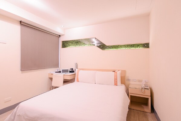 A hotel room with a bed, a desk, a chair, a telephone, and a small table. - Kiwi Express Hotel - Kaohsiung Station (Kaohsiung)