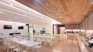 A modern dining area with wooden flooring, white tables, and chairs. - Kiwi Express Hotel - Kaohsiung Station (Kaohsiung)