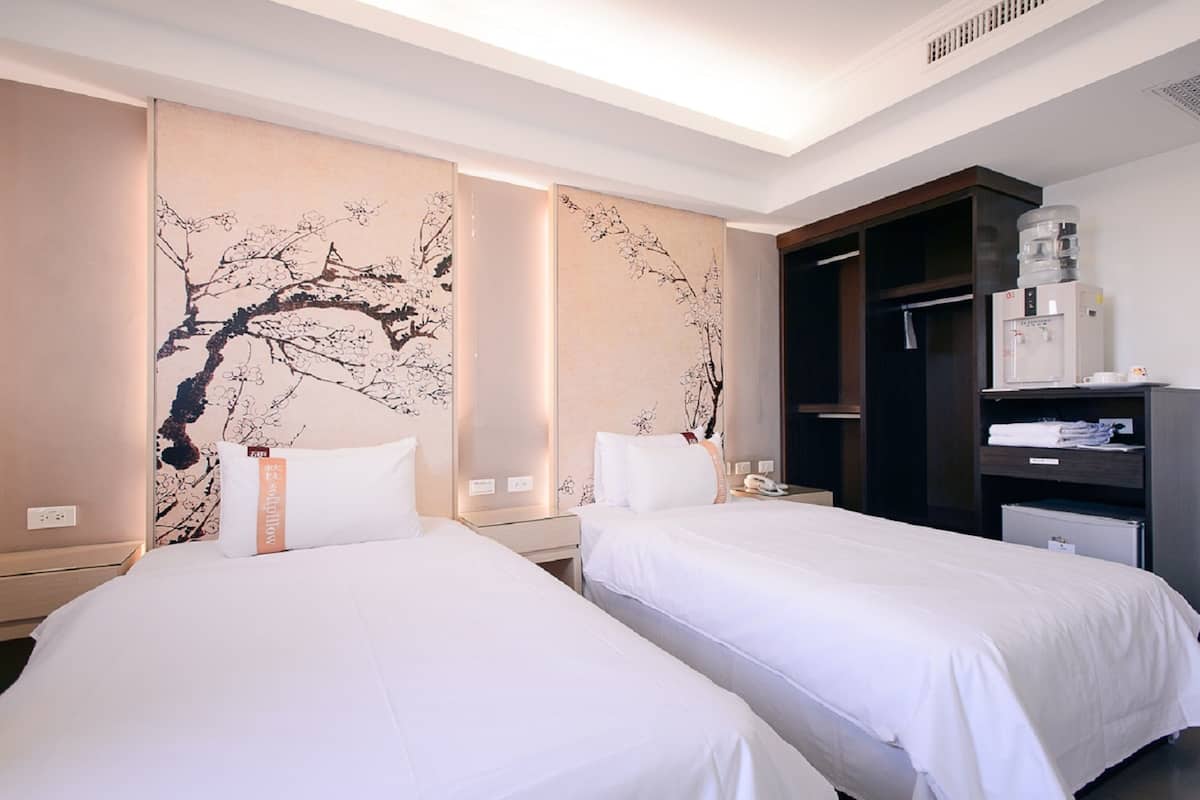Ein Hotelzimmer mit zwei Betten, einer Minibar und einem großen Wandbild.