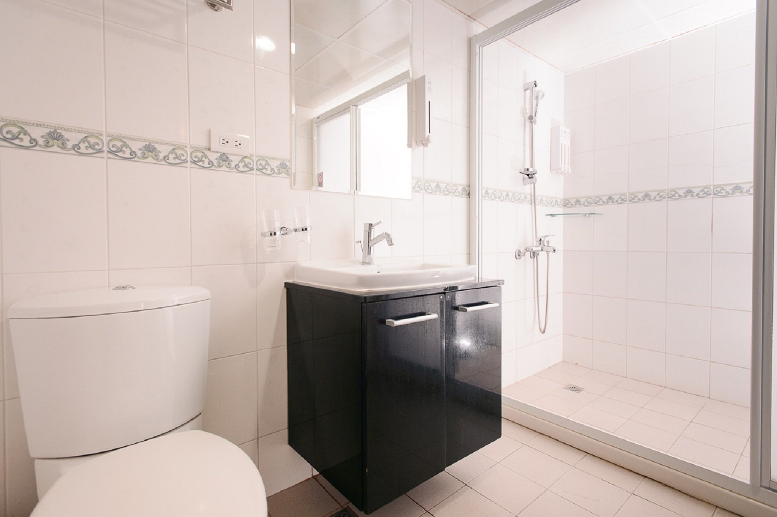 Un baño con inodoro, lavabo y zona de ducha.
