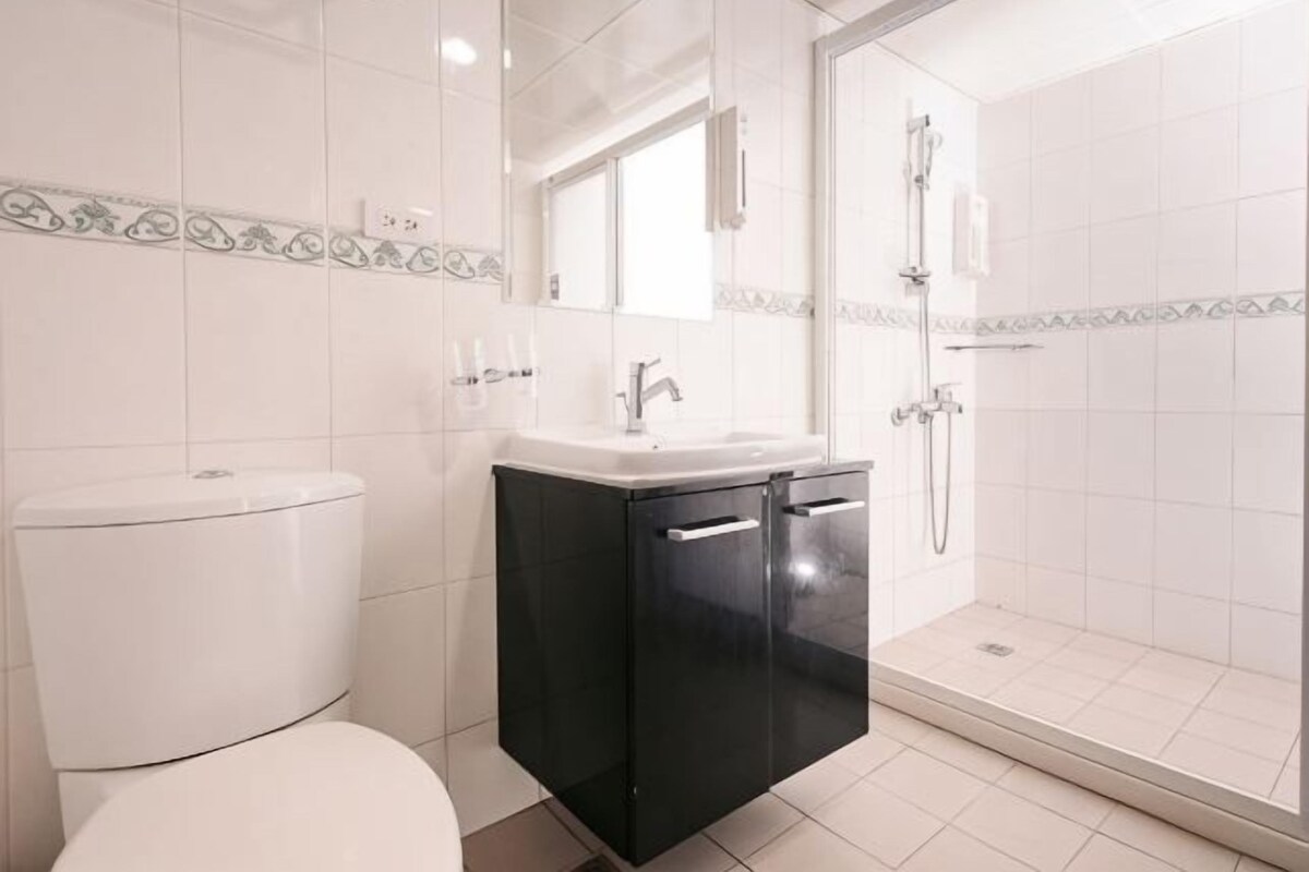 A bathroom with a toilet, sink, and shower.